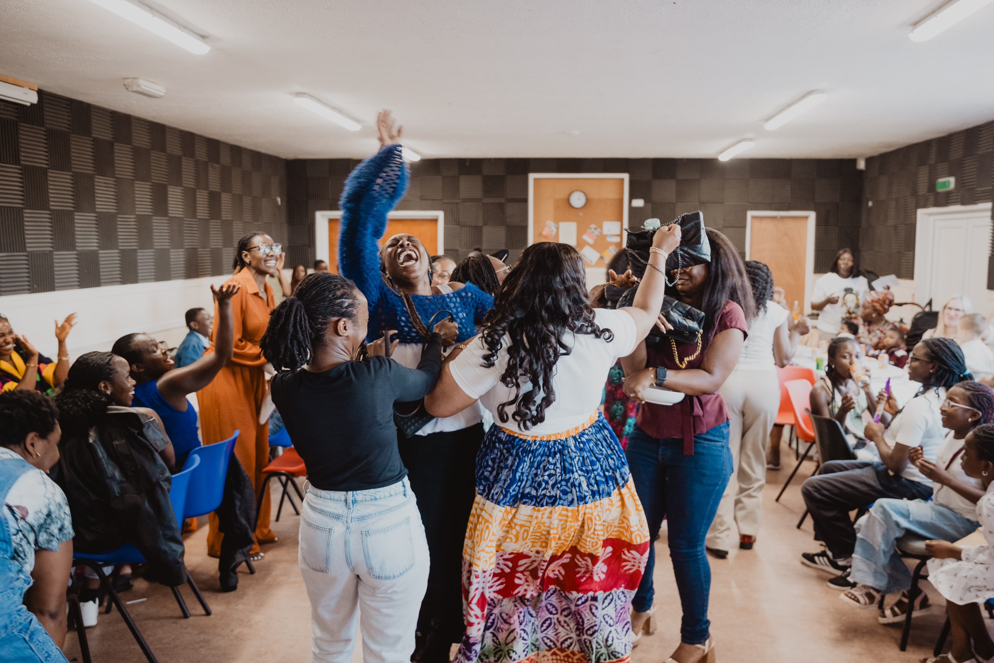 Women of colour together, smiling — a CWCC community gathering.